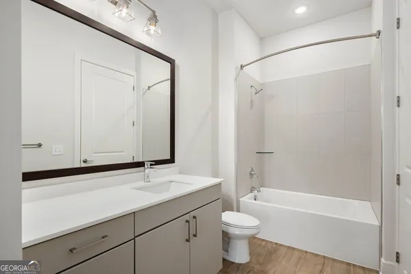 a bathroom with a bathtub shower sink vanity and toilet