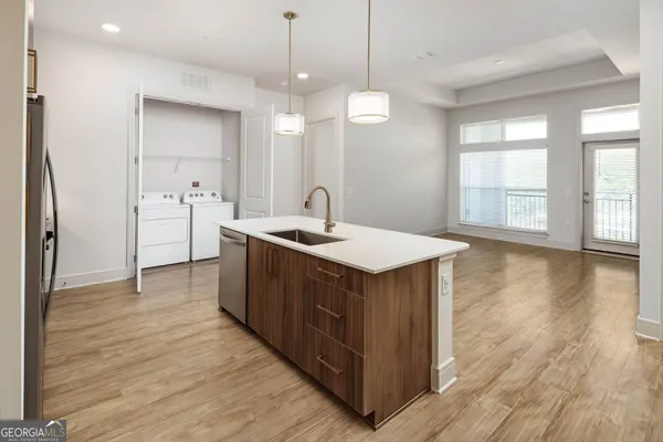 a kitchen with stainless steel appliances granite countertop a sink a counter space and wooden floor