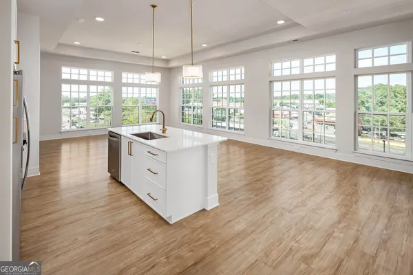 a kitchen with stainless steel appliances granite countertop a stove and a large window