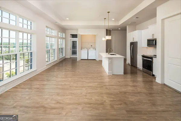 a view of a kitchen with furniture and wooden floor