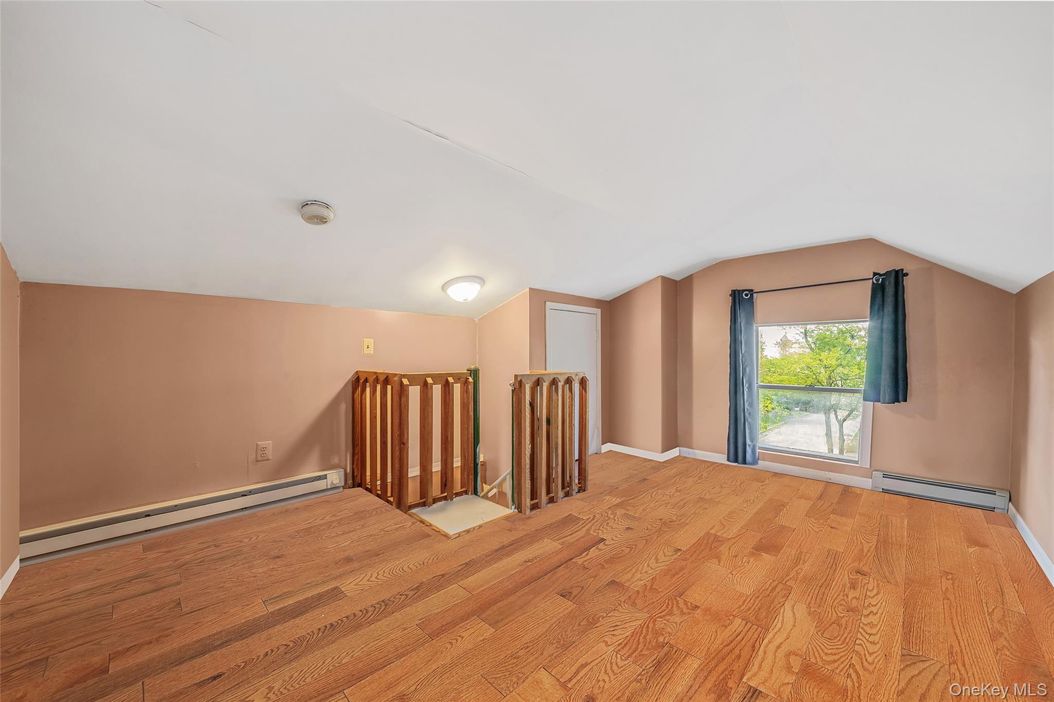 93 Maple Road Kings Park, NY 11754 - Photo 19 of 24 a view of an empty room with wooden floor and a window