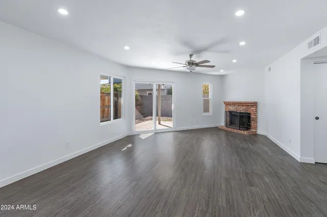 an empty room with wooden floor and fireplace