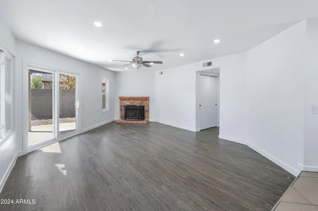 an empty room with wooden floor and a fireplace