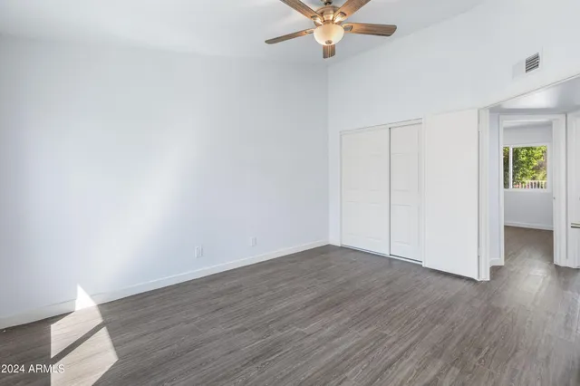a view of an empty room with wooden floor and a chandelier