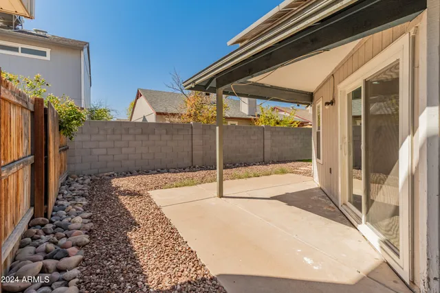 a backyard of a house with table and chairs