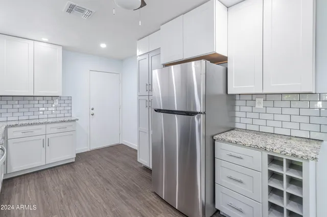 a kitchen with refrigerator cabinets and wooden floor