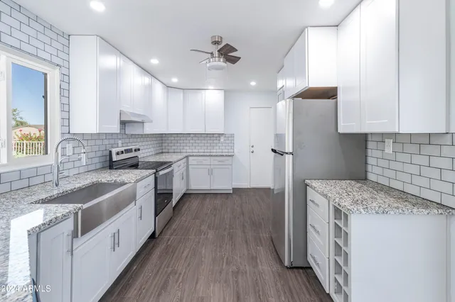 a kitchen with a sink a counter top space stainless steel appliances and cabinets