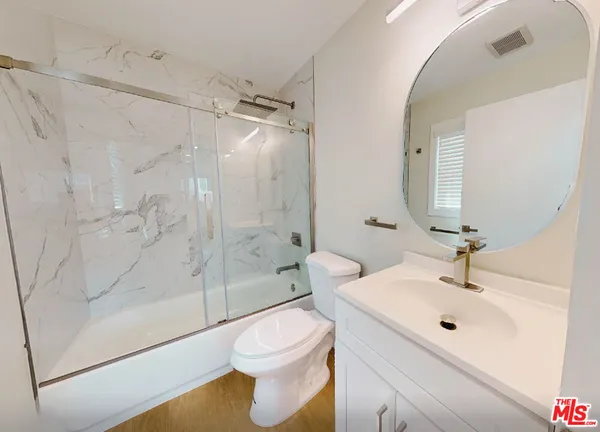 a bathroom with a sink mirror toilet and shower