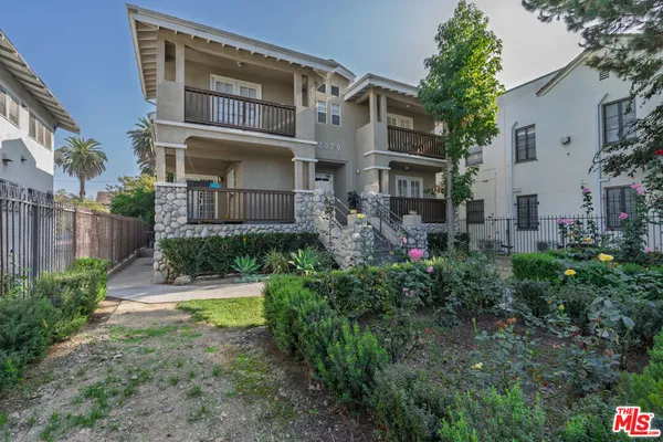 a front view of a residential apartment building with a yard
