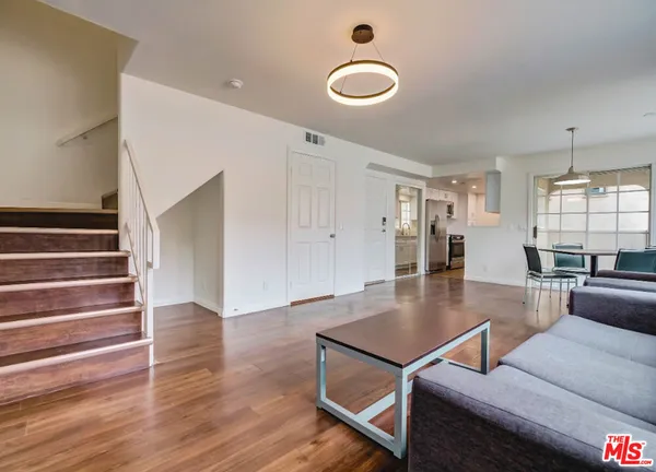 a living room with furniture wooden floor and potted plant
