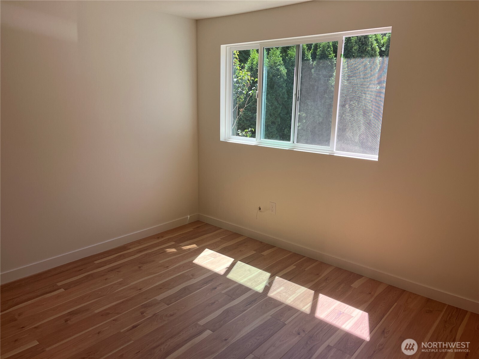 411 170th Place Southwest, Unit 2 Bothell, WA 98012 - Photo 11 of 15 a view of an empty room with wooden floor and a window