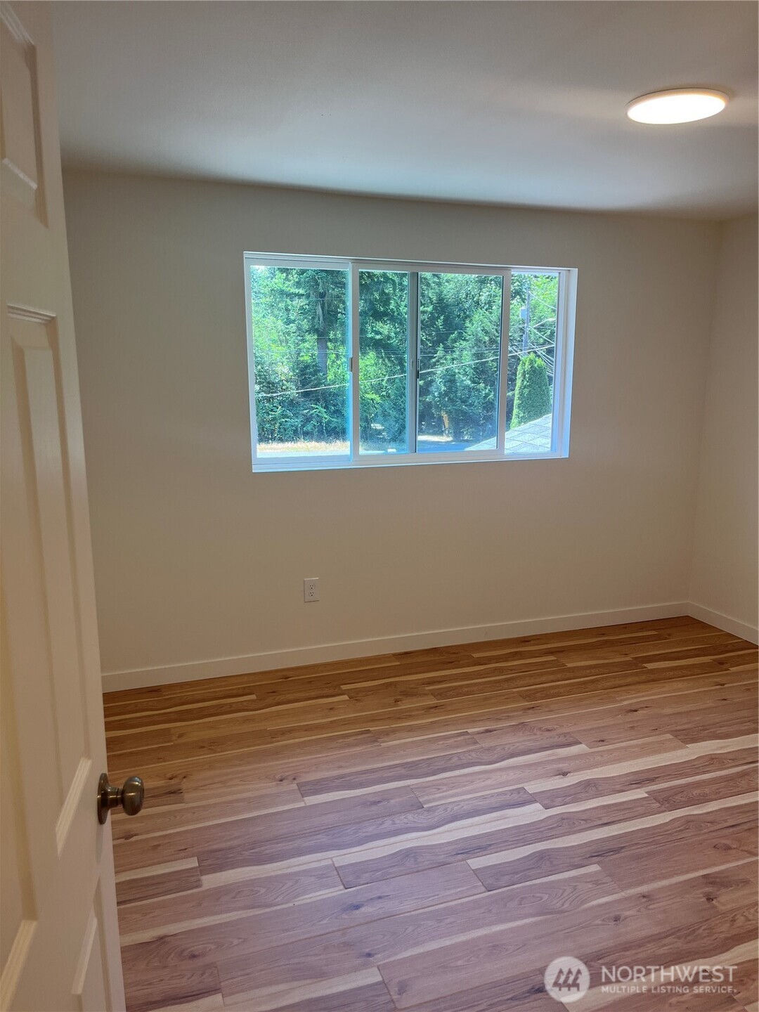 411 170th Place Southwest, Unit 2 Bothell, WA 98012 - Photo 12 of 15 a view of an empty room with wooden floor and a window