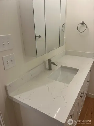 a bathroom with a sink a toilet and mirror