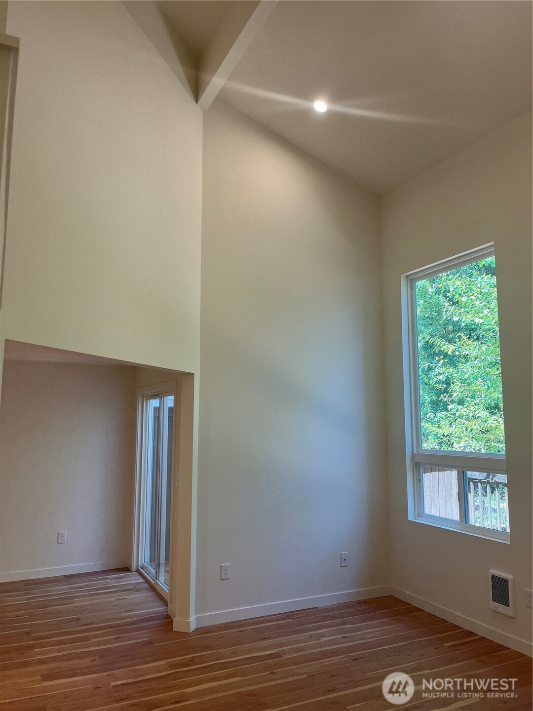411 170th Place Southwest, Unit 2 Bothell, WA 98012 - Photo 7 of 15 an empty room with wooden floor and windows