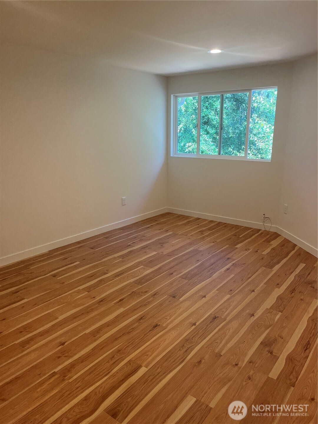 411 170th Place Southwest, Unit 2 Bothell, WA 98012 - Photo 10 of 15 an empty room with wooden floor and windows