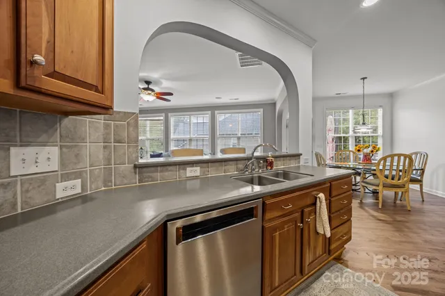 a kitchen with kitchen island a sink and a stove with wooden floors
