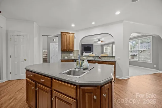 a kitchen with stainless steel appliances a sink a microwave cabinets and wooden floor
