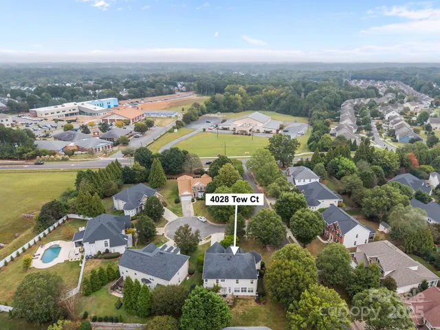 an aerial view of ocean and residential houses with outdoor space