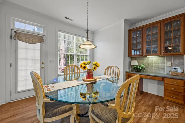 a dining room with furniture a chandelier and wooden floor