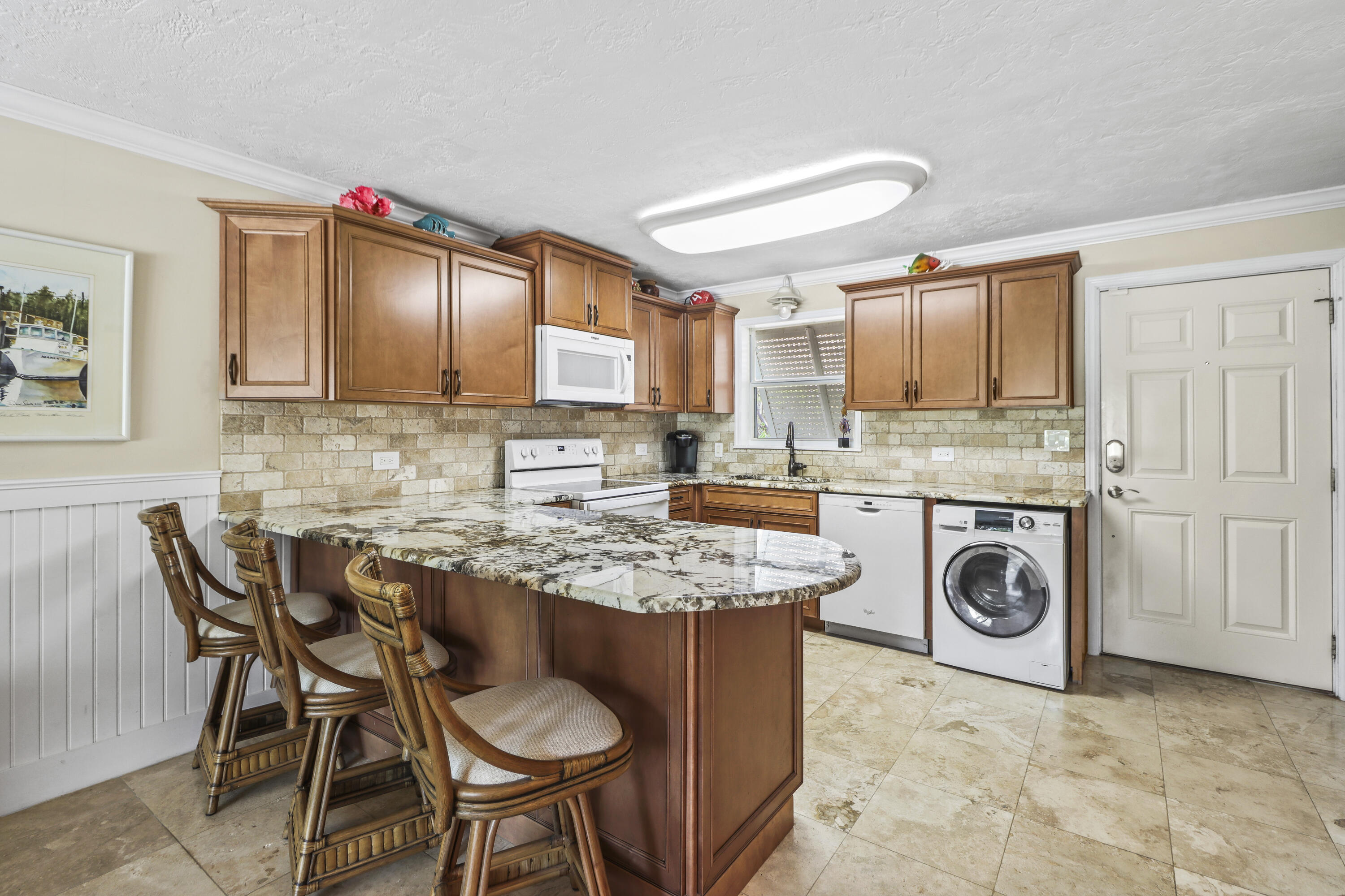 116 Indies Drive North Marathon, FL 33050 - Photo 35 of 67 a kitchen with kitchen island granite countertop a table chairs a stove a microwave and cabinets