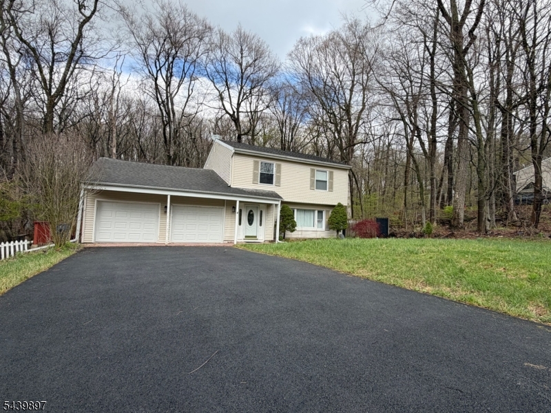 a view of a house with a yard and large trees