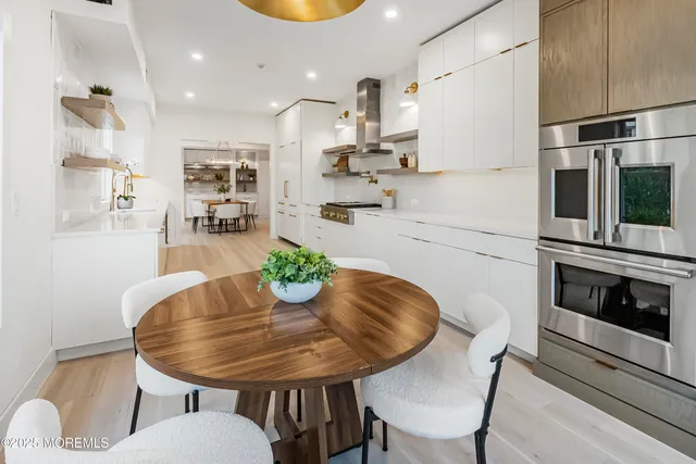 a kitchen with stainless steel appliances a dining table chairs and kitchen view