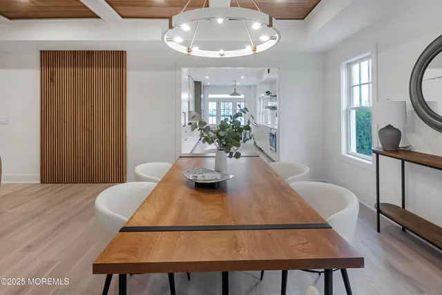 a view of a dining room with furniture and a chandelier