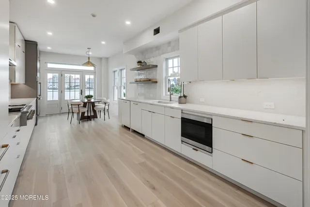 a kitchen with granite countertop a stove top oven a sink a dining table and chairs