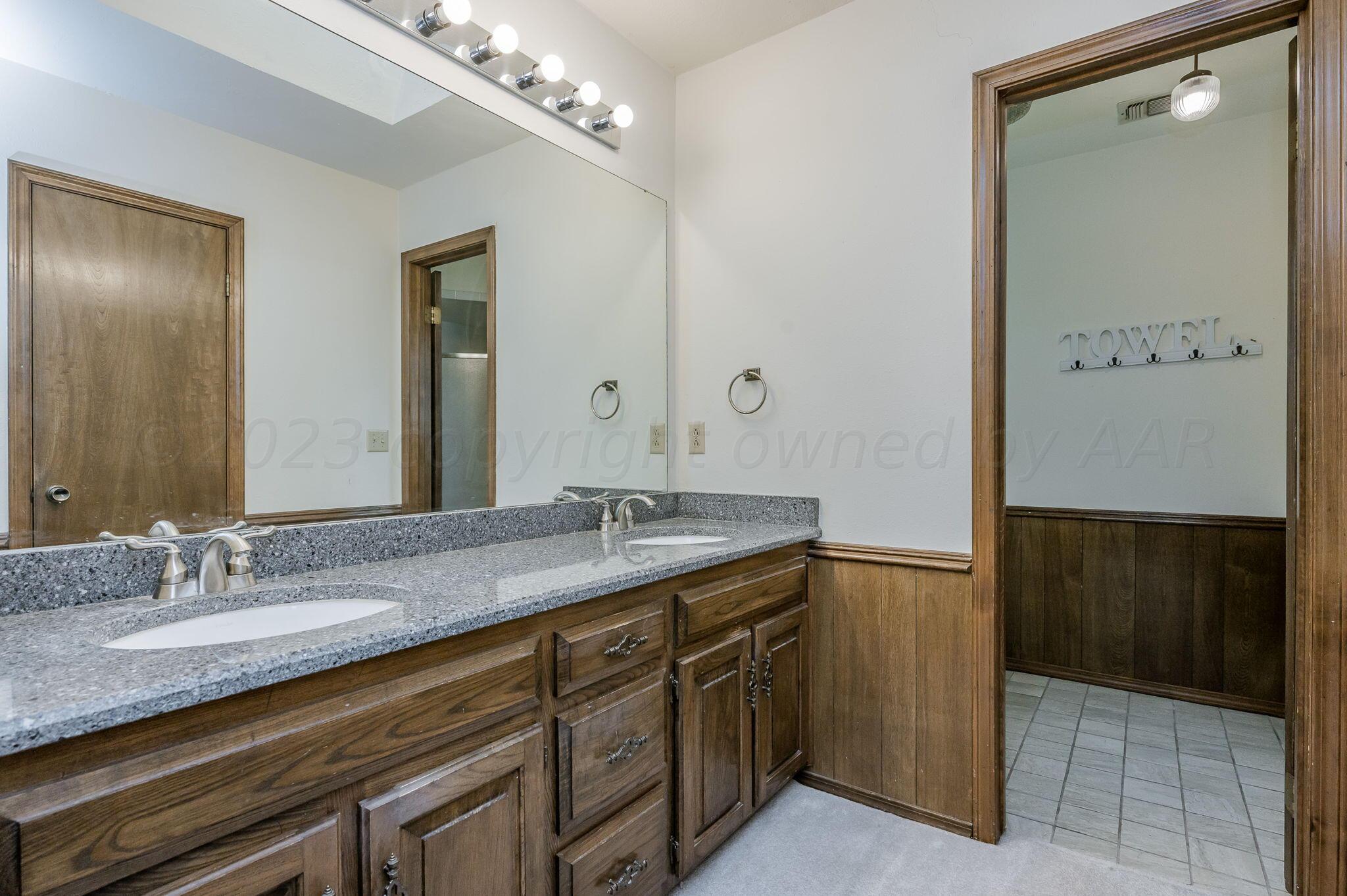 1109 Bennett Drive Dumas, TX 79029 - Photo 18 of 21 a bathroom with a granite countertop sink a mirror and a shower