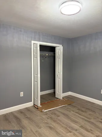an empty room with wooden floor and closet