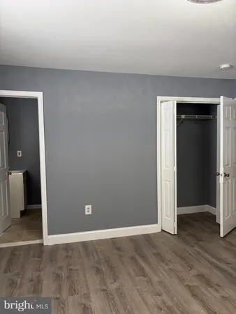an empty room with wooden floor and closet