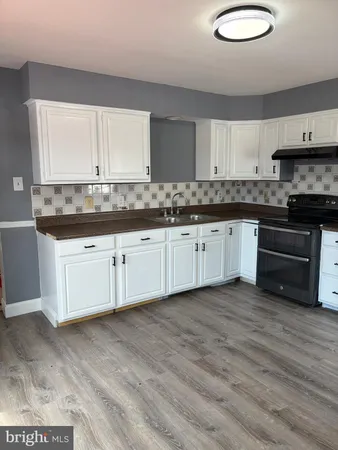 a kitchen with granite countertop a sink and cabinets