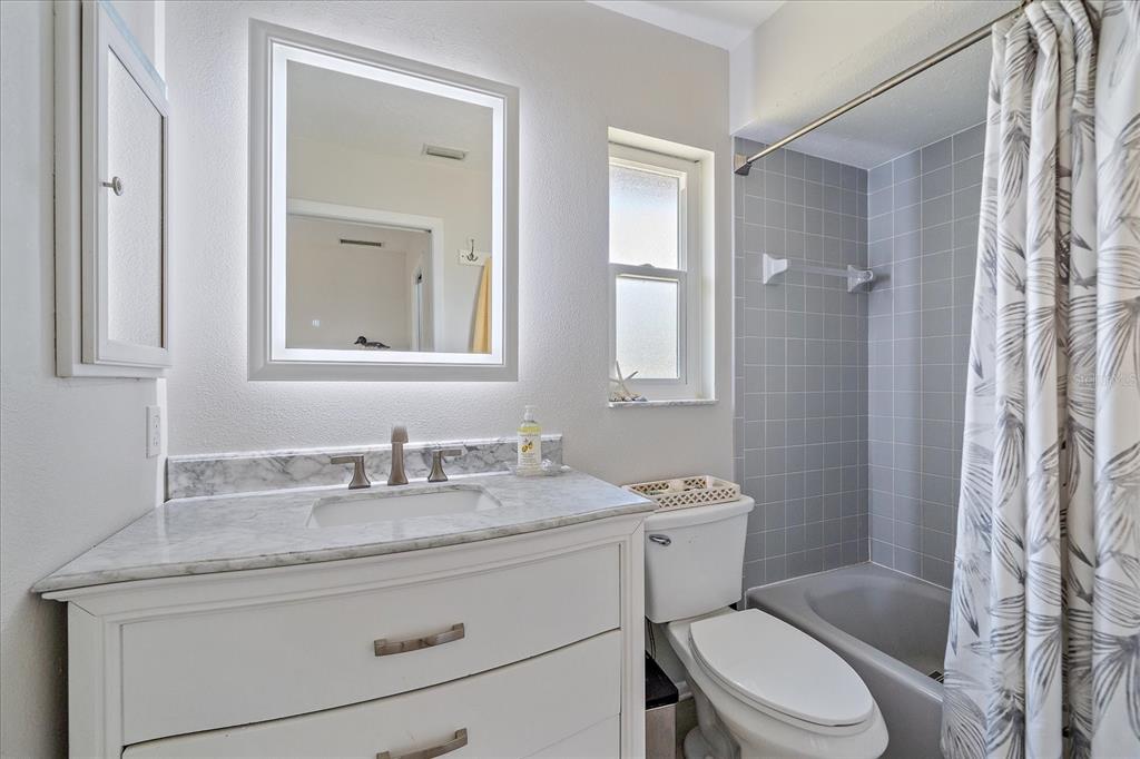 1488 Jupiter Road Venice, FL 34293 - Photo 6 of 21 a bathroom with a granite countertop toilet sink and a mirror