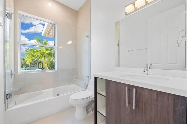a bathroom with a granite countertop sink a toilet and bathtub