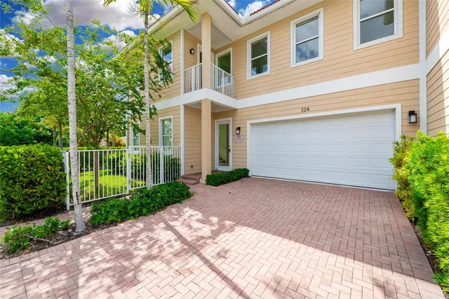 a view of a brick house with a yard and plants