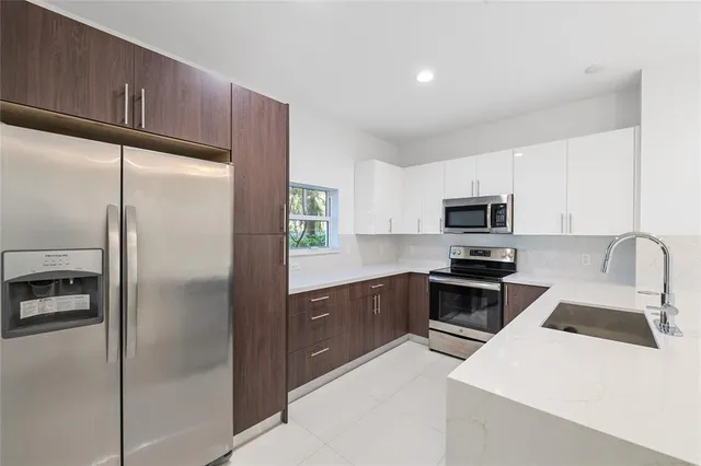 a kitchen with stainless steel appliances a refrigerator sink and microwave