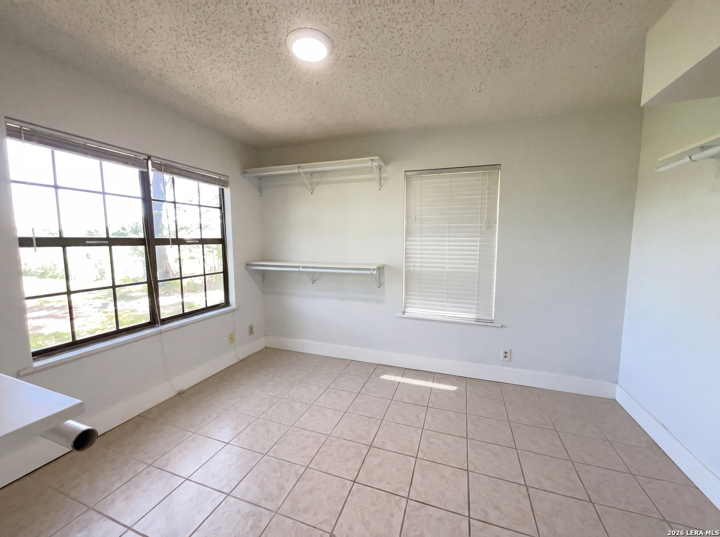 15422 Geronimo Loop San Antonio, TX 78254 - Photo 19 of 21 an empty room with windows and cabinet