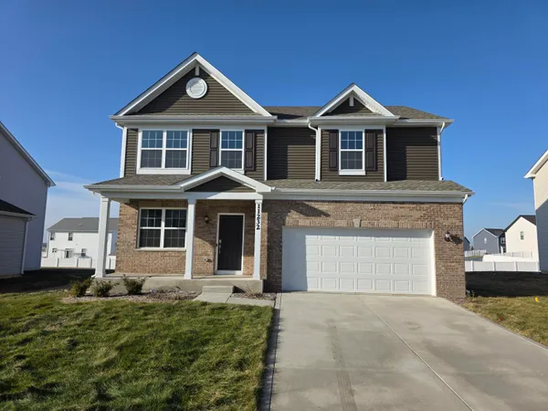 a front view of a house with a yard and garage