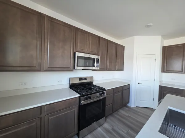 a kitchen with wooden cabinets and stainless steel appliances