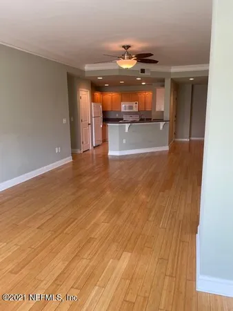 a view of a hallway with wooden floor and a living room
