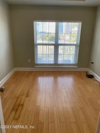 a view of a hallway with wooden floor and closet