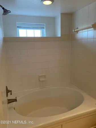 a living room with furniture large windows and wooden floor