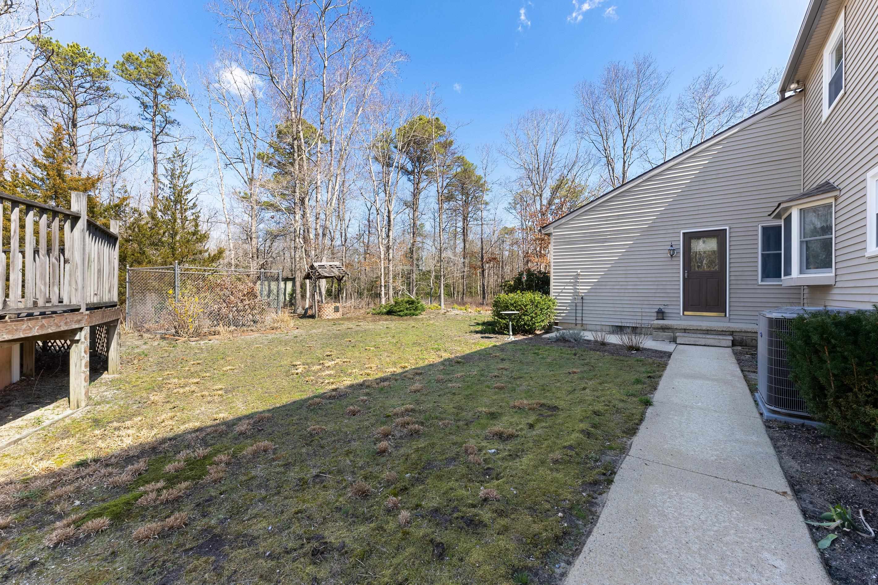 95 Peach Orchard Road Ocean View, NJ 08230 - Photo 40 of 41 a backyard of a house with large trees and outdoor seating