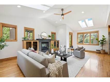 a living room with furniture kitchen view and a large window