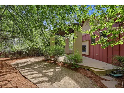 a kitchen with stainless steel appliances kitchen island granite countertop a refrigerator a sink a stove and white cabinets with wooden floor