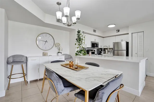 a kitchen with a table chairs and a chandelier