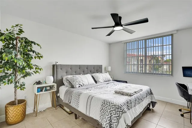a bedroom with a bed and a potted plant