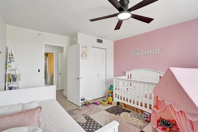 a living room with a baby crib furniture and a ceiling fan