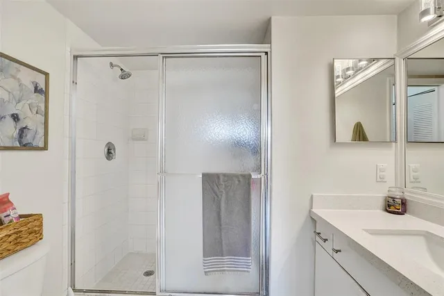a bathroom with a shower sink and mirror