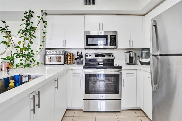 a kitchen with stainless steel appliances white cabinets and a stove